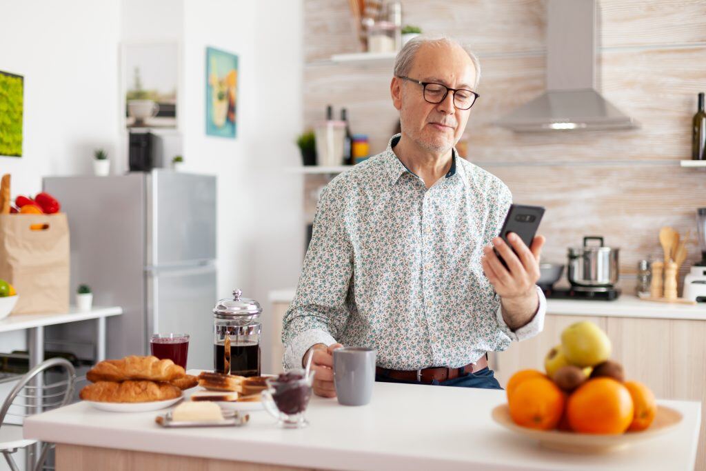 Mann schaut auf Smartphone - Videomarketing ist nicht nur ein Thema der jungen Generation