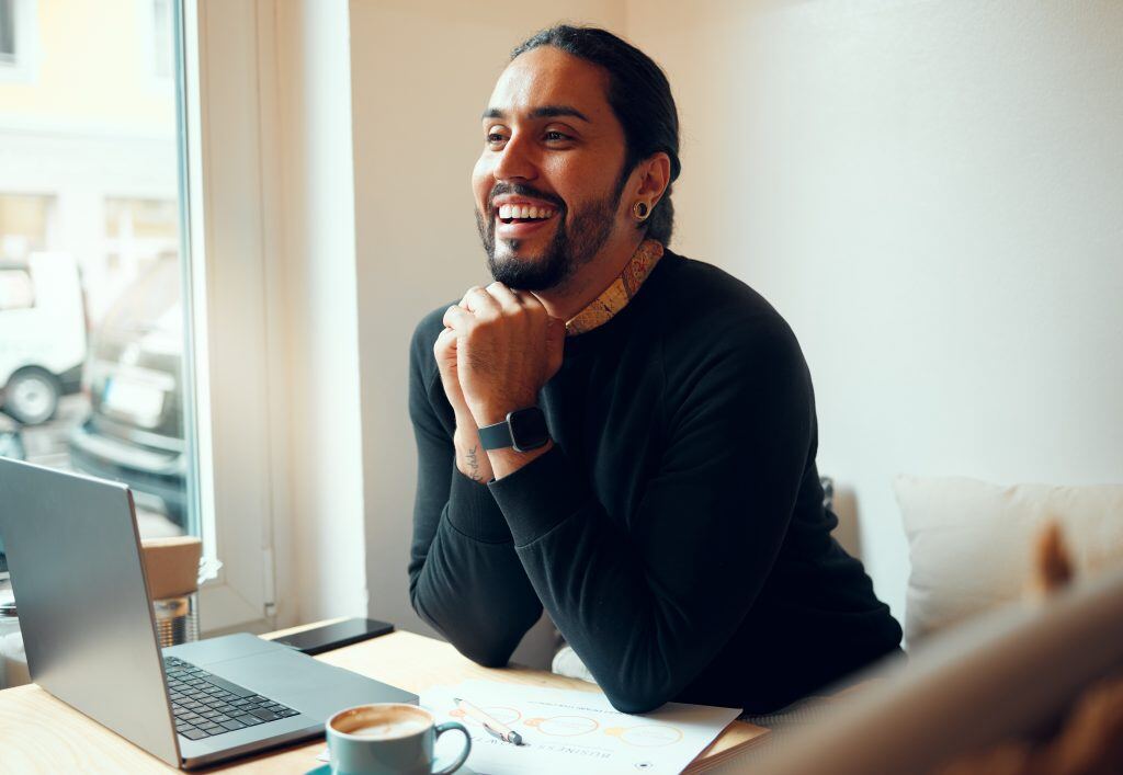 Laptop und lächelnder Mann, der über digitales Marketing, Beratung oder Unternehmensstrategien nachdenkt - Beim Coaching für Führungskräfte, Business Coaching. Und Business Training ist gerade im Marketing der Einsatz von State of the Art Tools essentiell.