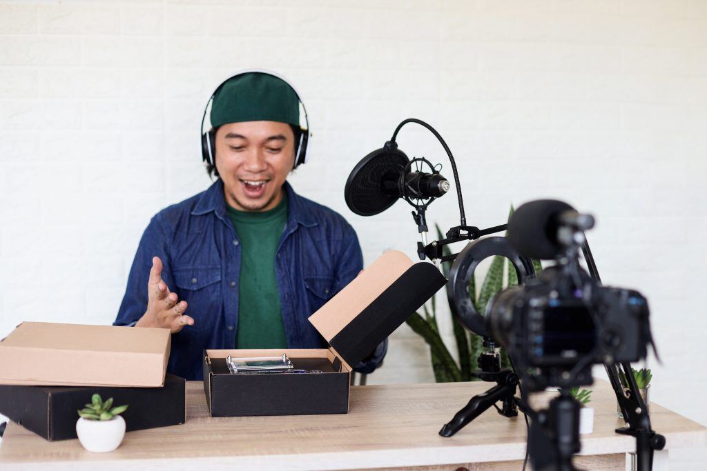Ein Mann nimmt ein unboxing-Video auf - die Videomarketing-Analyse ist wichtig um herauszufinden welcher Content bei Ihrer Zielgruppe ankommt