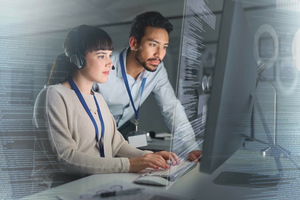 Ein Mann und eine Frau sitzen vor einem PC und sehen Daten - Nutzen Sie passende CRM Prozesse, um Routine Aufgaben zu automatisieren und zu vereinfachen