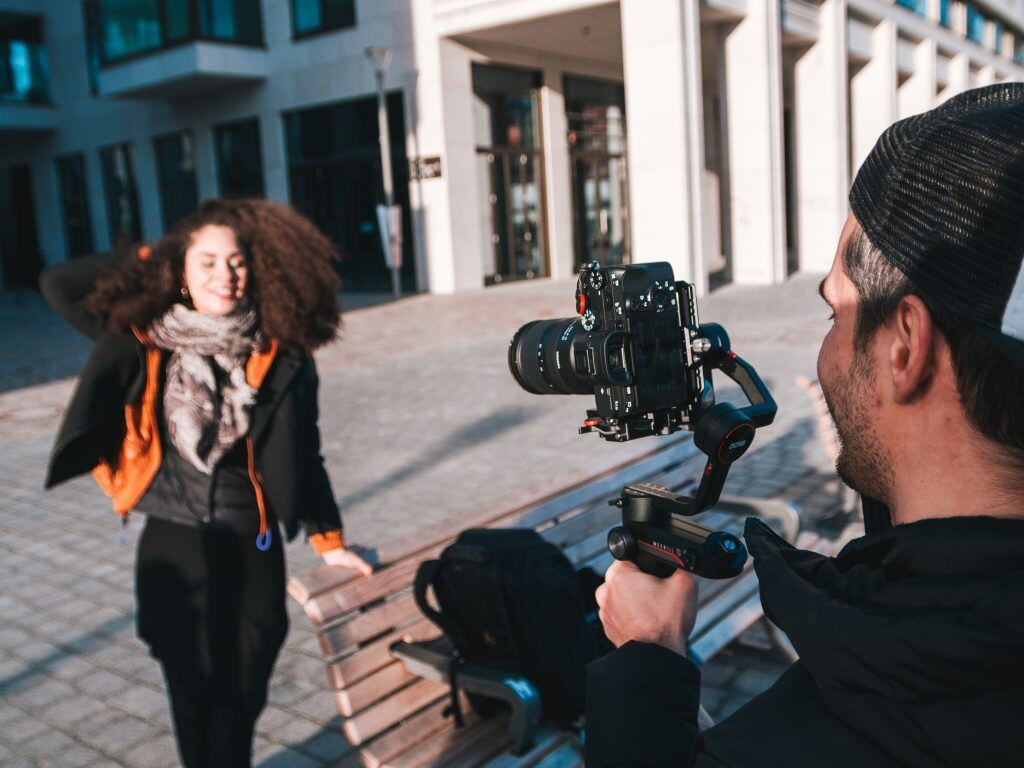 Ein Mann nimmt mit einem Gimbal ein vertikales Video auf - Videoproduktion für Social Media ist ein wichtiger Bestandteil jeder Marketing-Strategie