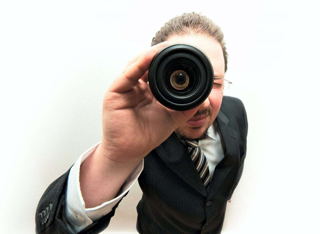 Ein Mann schaut durch ein Fernglas - Wird Ihr Unternehmensvideo überhaupt gefunden? Mit Video SEO können Sie dafür sorgen.
