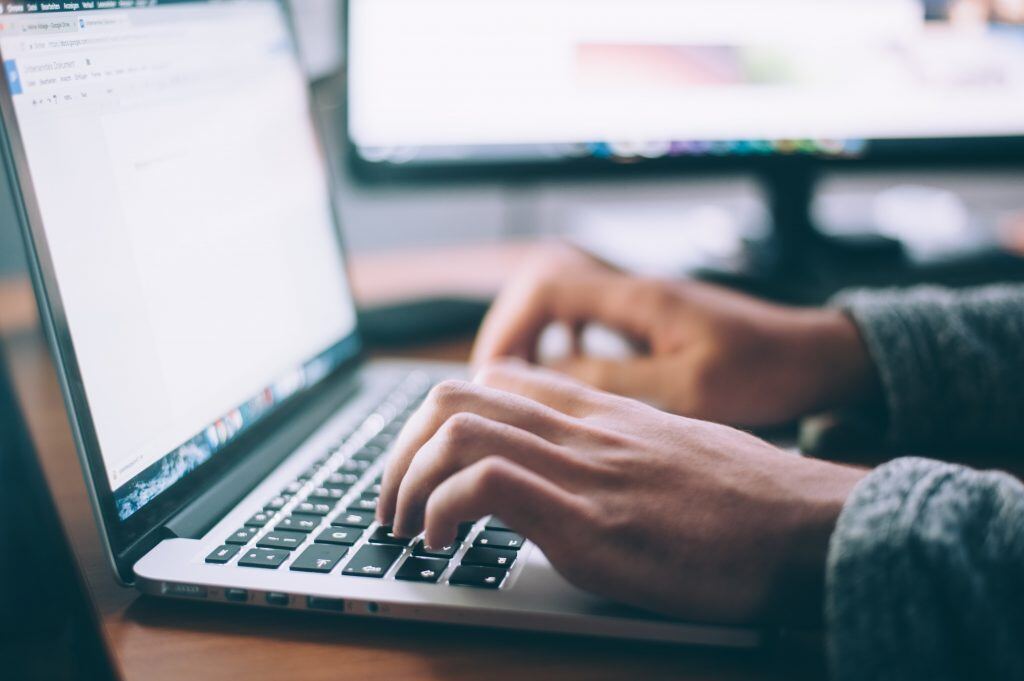 Digitale Mitarbeiterschulung und Online Lernkurse helfen Unternehmen bei der Aus- und Weiterbildung Ihrer Mitarbeiter -  Ein Mann sitzt am Laptop