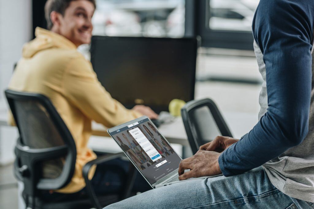 Zwei Mitarbeiter sprechen miteinander: Wenn Sie LinkedIn Marketing nutzen, um Mitarbeiter zu gewinnen, achten Sie darauf, Testimonials einzusetzen.