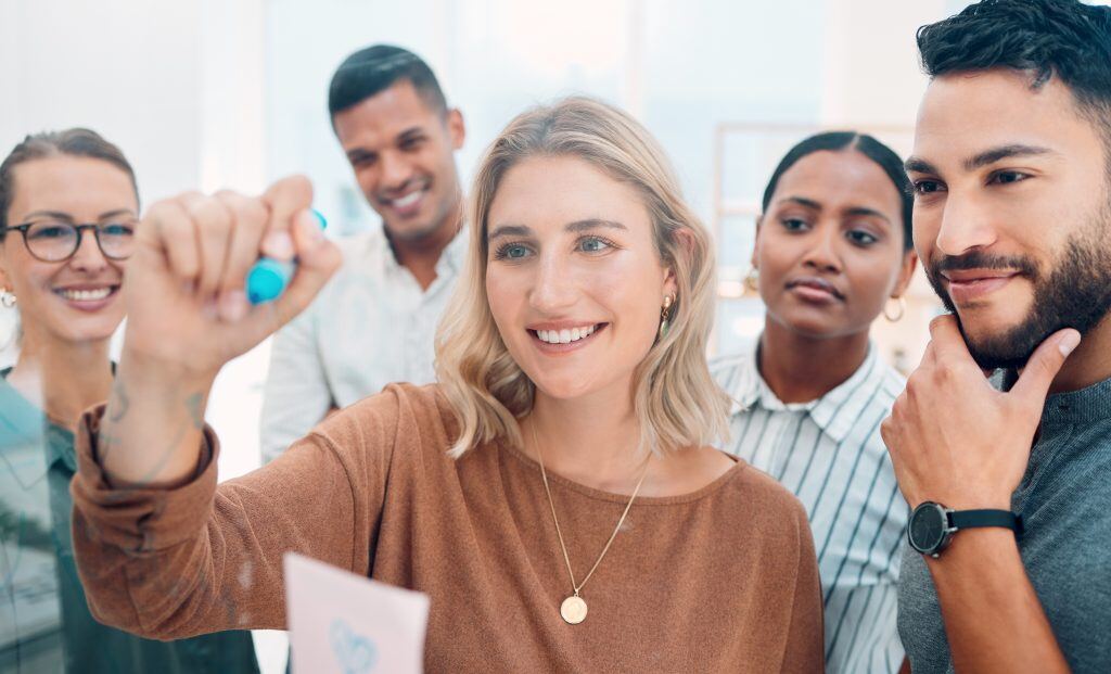 Ein Marketing Team Schreibt auf einen Flipchart - Coaching für Führungskräfte im Marketing ist wichtig, damit sie up to date bleiben Business Coaching unterstützt dabei die beruflichen Ziele zu erreichen.