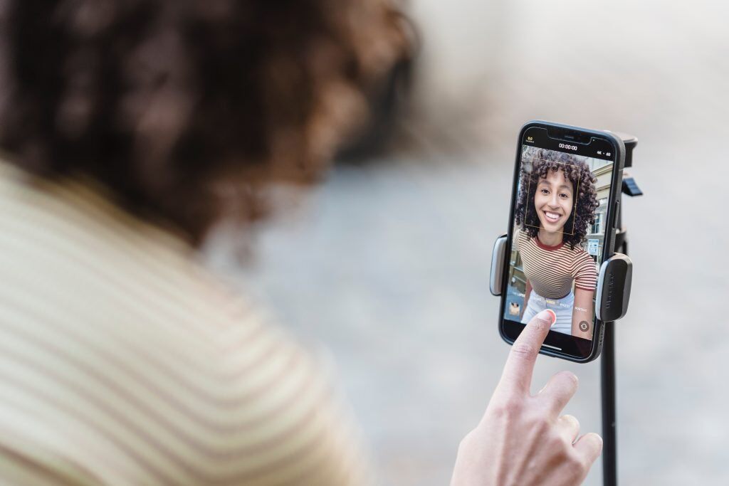 Eine Frau nimmt ein Instagram Reel auf - Videomarketing zur Mitarbeitergewinnung lässt sich über Reels oder TikToks hervorragend umsetzen.