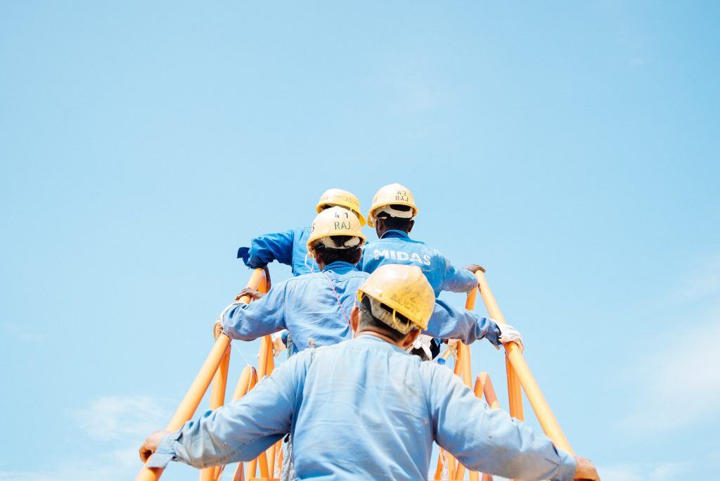 Handwerker gehen eine Rolltreppe hinauf - Social Recruiting ist eine attraktive Möglichkeit dem Fachkräftemangel entgegenzuwirken