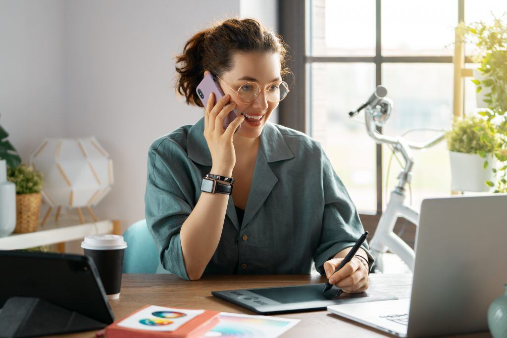 Eine Frau telefoniert im Büro - Zielgerichtetes und konstruktives Feedback für die Marketingagentur ist bei einer Marketingkampagne der Schlüssel zum Erfolg